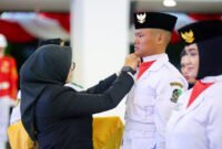 Siap Bertugas - Bupati Banyuwangi, Ipuk Fiestiandani menyematkan pin dan tanda dikukuhkannya anggota paskibraka Banyuwangi yang siap bertugas di upacara HUT Ke-80 Kemerdekaan RI (Foto : istimewa/Jatim.co)