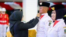 Siap Bertugas - Bupati Banyuwangi, Ipuk Fiestiandani menyematkan pin dan tanda dikukuhkannya anggota paskibraka Banyuwangi yang siap bertugas di upacara HUT Ke-80 Kemerdekaan RI (Foto : istimewa/Jatim.co)
