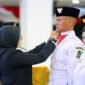 Siap Bertugas - Bupati Banyuwangi, Ipuk Fiestiandani menyematkan pin dan tanda dikukuhkannya anggota paskibraka Banyuwangi yang siap bertugas di upacara HUT Ke-80 Kemerdekaan RI (Foto : istimewa/Jatim.co)