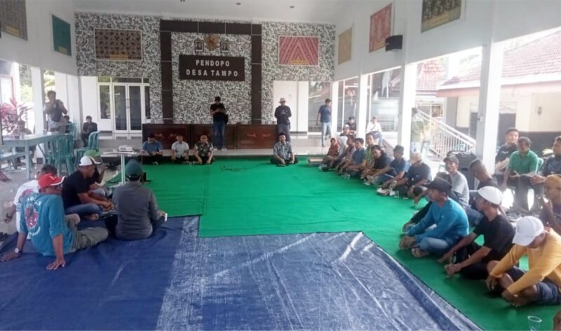 Dialog - Kepala Desa dengan didampingi Forum Pimpinan Kecamatan Cluring menerima warga yang melakukan aksi dan dialog bersama perwakilan warga dengan duduk lesehan didalam pendopo balai desa (Foto : Jatim.co)