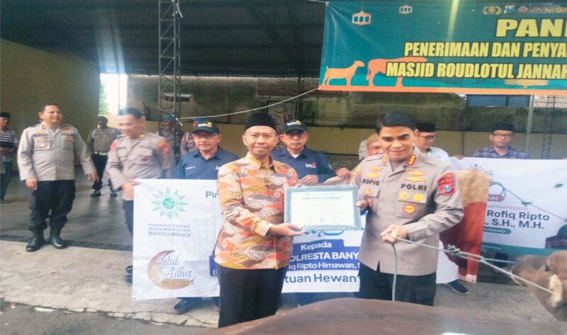 SALURKAN KURBAN : Kapolresta Banyuwangi Kombes Pol. Dr.Rofiq Ripto Himawan simbolis menyerahkan penyaluran hewan kepada Ainur Rofiq yang mewakili Pimpinan Daerah Muhammadiyah Banyuwangi didepan Masjid Roudhotul Jannah Polresta Banyuwangi. (Rizkie/Jatim.co)