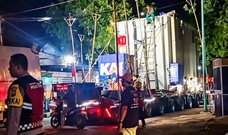 TRAFO RAKSASA LEWAT - Polisi dan pertugas mengawal iringan truk pengangkut trafo raksasa berukuran lebih dari 200 ton lewat jalur jalan nasional Banyuwangi-Kalipuro (Foto : Jatim.co) 