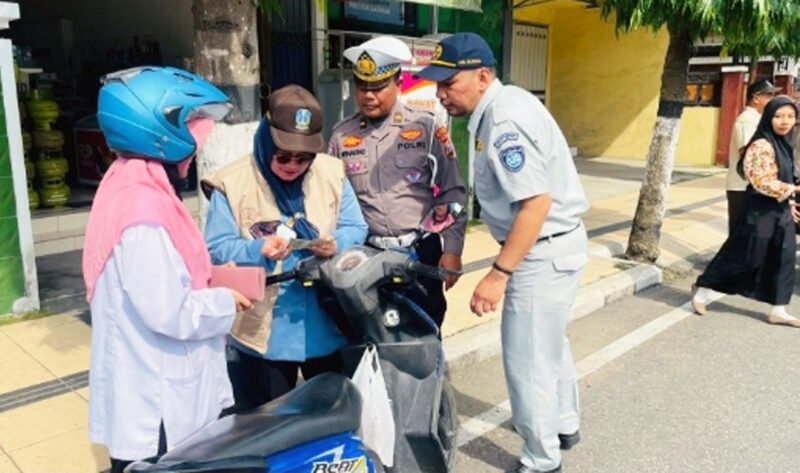 TERTIB LALU LINTAS DAN ADMINISTRASI KENDARAAN : Petugas gabungan lalu lintas, Bapenda dan Jasa Raharja melakukan razia kelengkapan kendaraan bermotor dan edukasi pentingnya tertib administrasi kendaraan sembari memberikan hadiah kepada pengendara yang tertib. (Foto : Jatim.co)